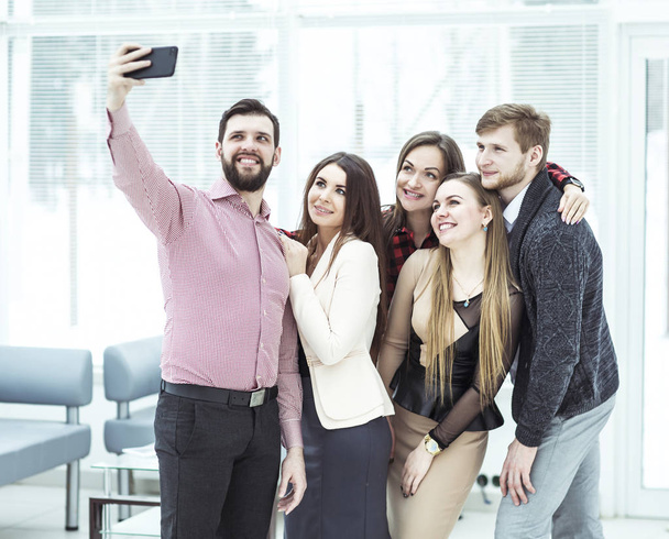 friendly business team taking a selfie while standing near window in office - Foto, afbeelding