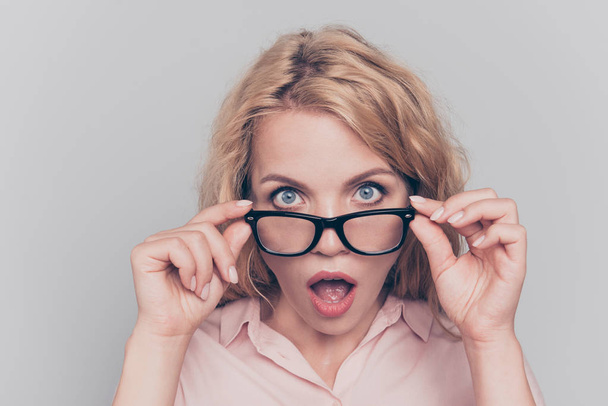 Wow! Surprised pretty young blonde touching looks over the glasses wide open eyes and mouth with surprise isolated on gray background - Φωτογραφία, εικόνα