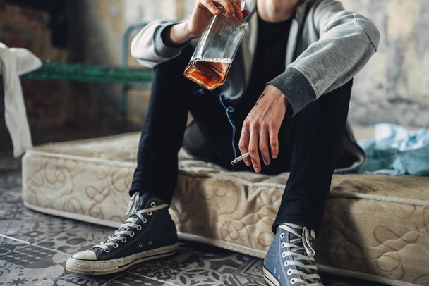 Young man smoke cigarette and drinking alcohol  - Photo, image