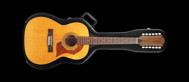 Musical instrument - Vintage twelve-string acoustic guitar from above on a hard case hard case isolated on a black background. - Photo, Image