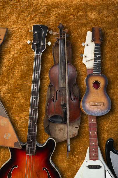 Strumento musicale - Basso Vintage chitarra, acustica, violino, balalaika su uno sfondo marrone peluche
. - Foto, immagini