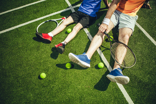 Male and kid feet resting on court - 写真・画像