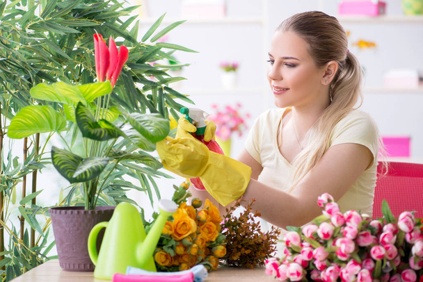Giovane donna che innaffia le piante nel suo giardino - Foto, immagini