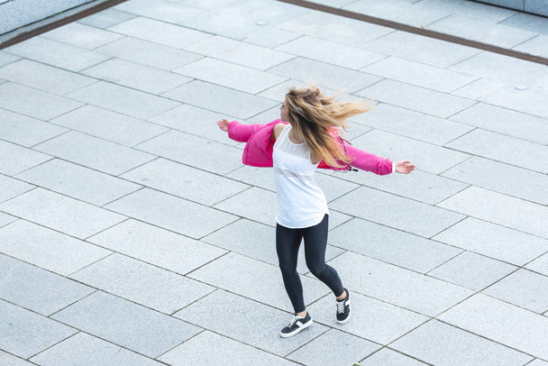 high angle view of young stylish female urban dancer dancing at city street - Fotoğraf, Görsel