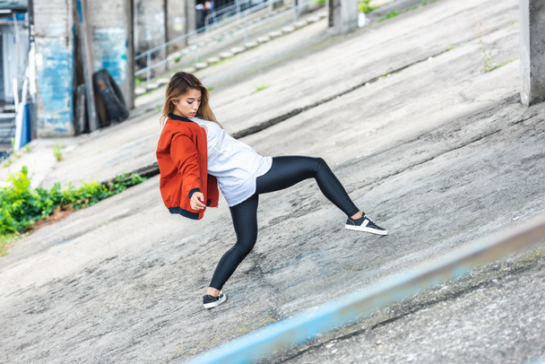 young asian stylish female urban dancer dancing at city street - Zdjęcie, obraz