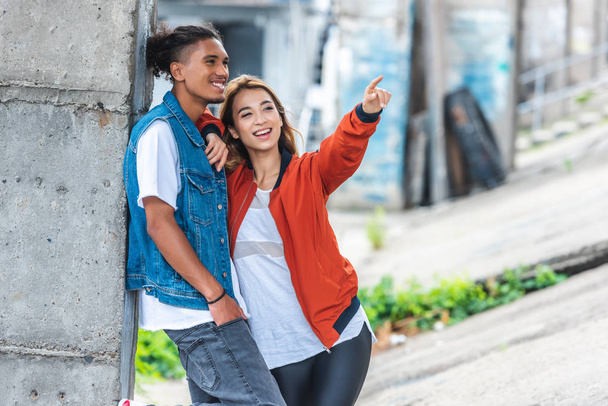 happy asian woman pointing by finger to mixed race boyfriend at city street  - Zdjęcie, obraz