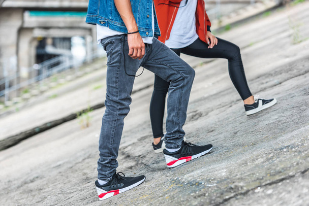cropped image of stylish young couple standing at city street - Foto, imagen