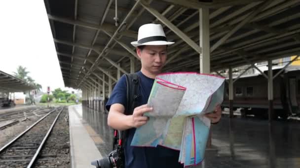 Asiático saco homem pacote turista com mapa na estação ferroviária na Tailândia
 - Filmagem, Vídeo