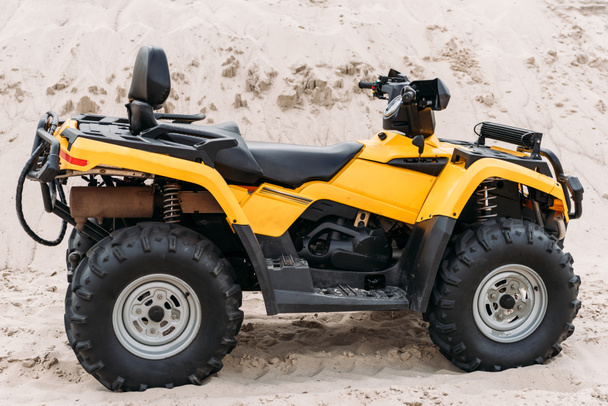 side view of modern yellow all-terrain vehicle standing in desert on cloudy day - Foto, Imagem