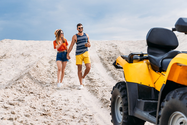 relaxed young couple with atv and coconut cocktails in desert on cloudy day - Fotografie, Obrázek