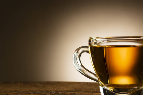 closeup of glass cup of tea on wooden table - Valokuva, kuva