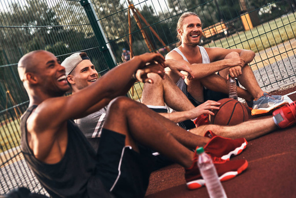 jugadores de baloncesto sentados en el suelo de la cancha y relajante
  - Foto, Imagen