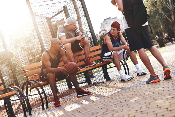 basketball players sitting on bench and talking - Fotoğraf, Görsel