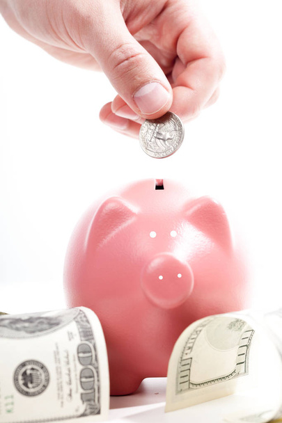 Savings - Piggy bank and hand with coin - Fotografie, Obrázek