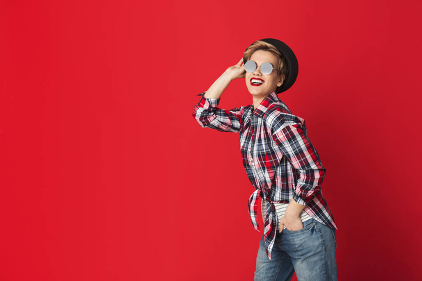 Teen fashion. Happy girl in casual clothes at red background - Photo, Image