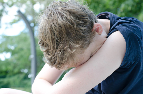 Teenage boy with head in arms - Photo, Image