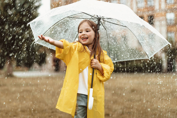 Criança positiva pegando gotas de chuva fora
 - Foto, Imagem