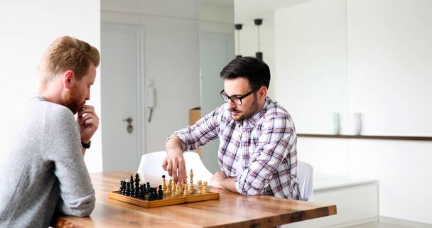 Portrait of two young men playing intelligent game of chess - Foto, Bild