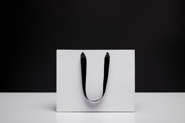 one white shopping bag on white table isolated on black - Fotoğraf, Görsel