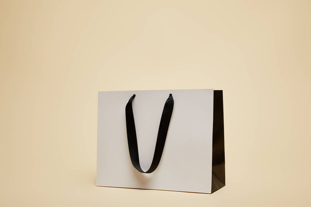 one white shopping bag isolated on beige - Fotoğraf, Görsel