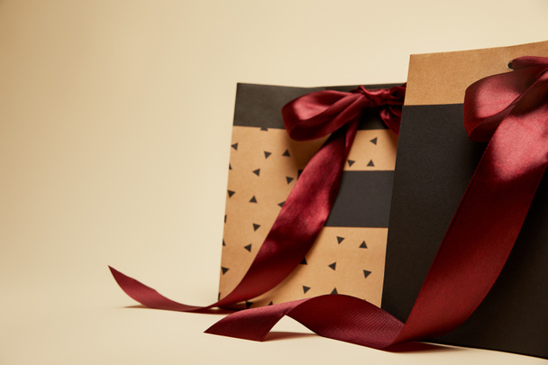 fashionable brown and black shopping bags with bows isolated on beige  - Photo, Image