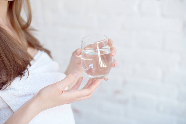 Female hands holding a clear glass of water - Foto, imagen