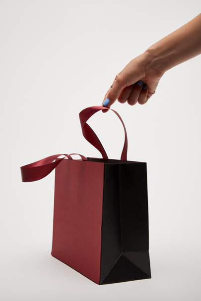 cropped image of woman touching burgundy shopping bag isolated on white - Fotografie, Obrázek