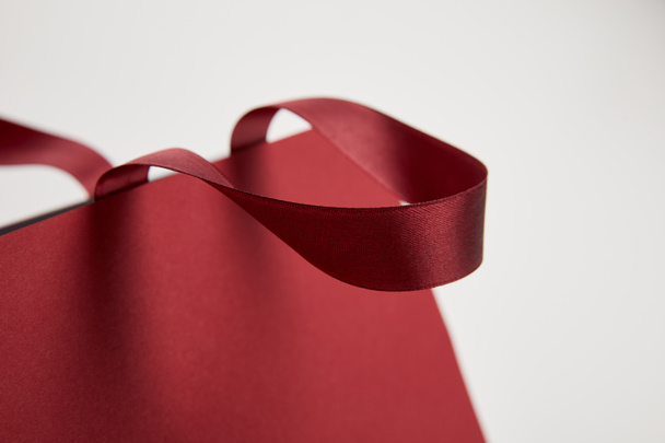 close up of handle of burgundy shopping bag isolated on white - Foto, Bild