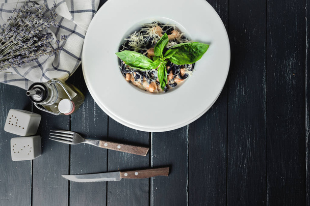 Black pasta with salmon in white plate  - Foto, Imagen