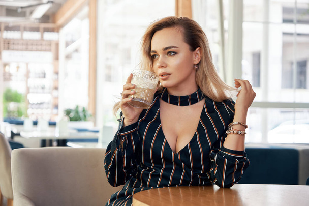 Πορτρέτο πανέμορφη γυναίκα που κάθεται σε ένα καφέ με ένα ποτό - Φωτογραφία, εικόνα