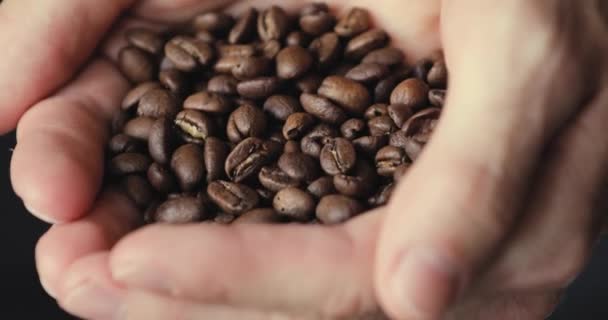 Male hands strewing harvest coffee granules from palm - Felvétel, videó