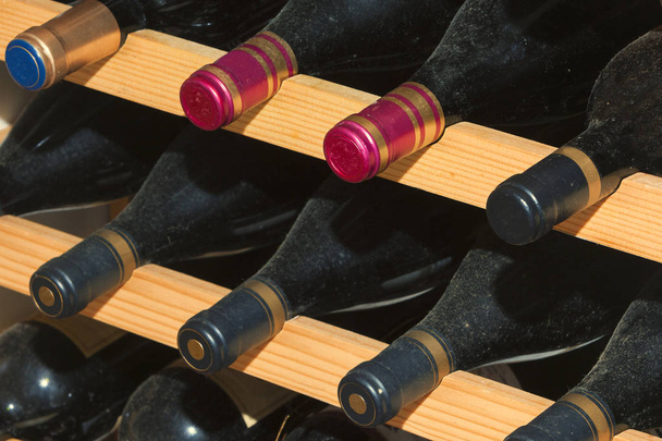 Cave à vin, avec bouteilles sur étagères en bois
 - Photo, image