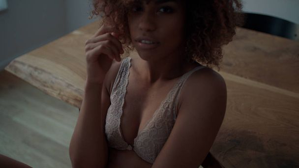 Beautiful cheerful Afro American woman in lingerie posing at home. - 写真・画像