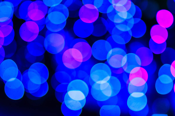 Beautiful blue bokeh abstract light background. Wonderful Defocused abstract blue christmas background. Abstract christmas lights as background in the night with noise grain and poor light. - Fotó, kép