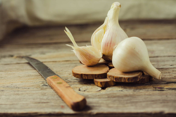 Fresh young organic garlic on a gray wooden background. Selective focus.Autumn fresh vegetables - Photo, Image