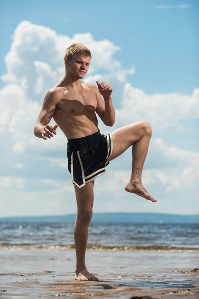 athlete warm up before training against the sea - Foto, afbeelding
