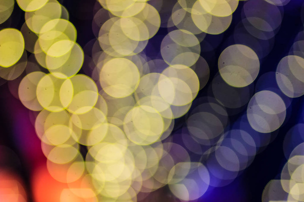 Beautiful blue bokeh abstract light background. Wonderful Defocused abstract blue christmas background. Abstract christmas lights as background in the night with noise grain and poor light. - 写真・画像