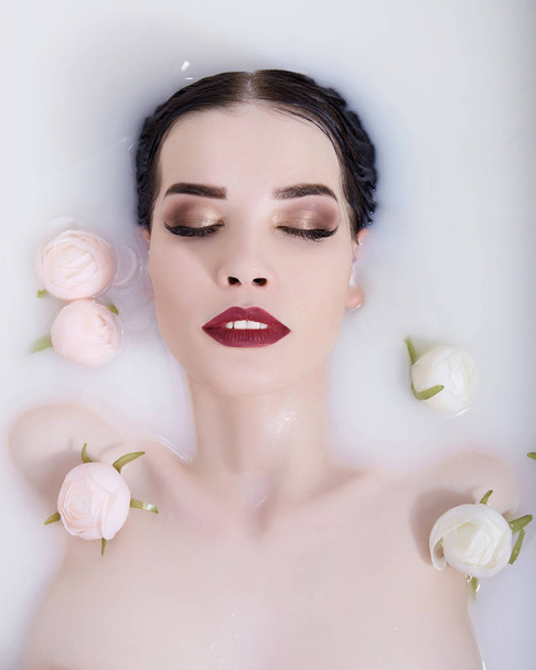 beautiful sexy girl in milk with flowers.beauty young nude woman in spa bath - Φωτογραφία, εικόνα