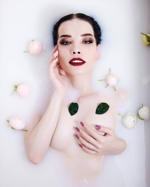 hermosa chica sexy en la leche con flores.beauty joven mujer desnuda en bañera de hidromasaje
 - Foto, imagen