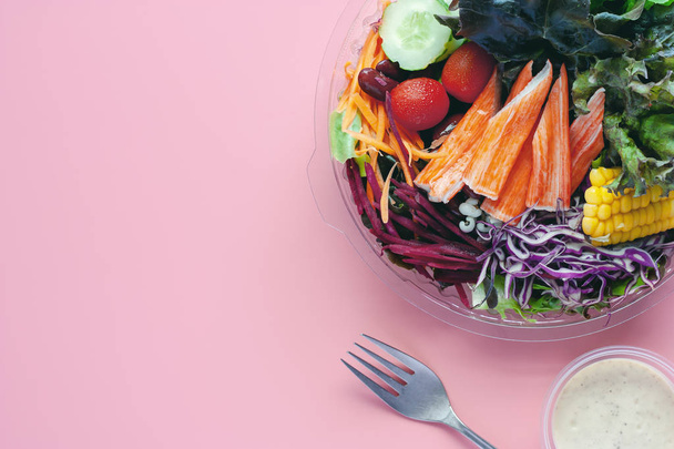 Légumes frais avec vinaigrette à salade et fourchette sur fond rose et espace de copie pour l'alimentation et le concept de manger santé
 - Photo, image