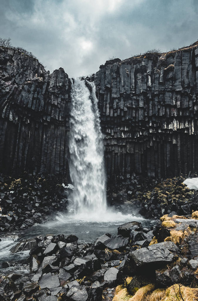 Dramatic morning view of famous Svartifoss Black Fall Waterfall. Colorful summer sunrise in Skaftafell, Vatnajokull National Park, Iceland, Europe. Artistic style post processed photo. - Фото, изображение