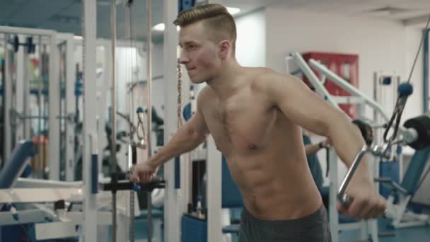 Sport and Healthy Life Style Concept. Handsome sporstman with muscles and naked torso training his triceps on fitness station. 4k. - Záběry, video