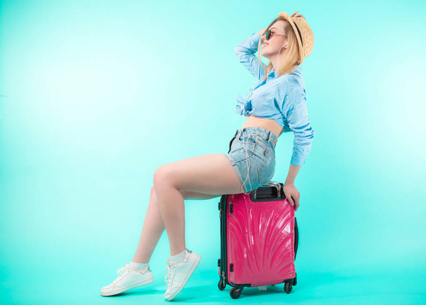 side view full length portrait of happy woman riding the luggage - Foto, Bild