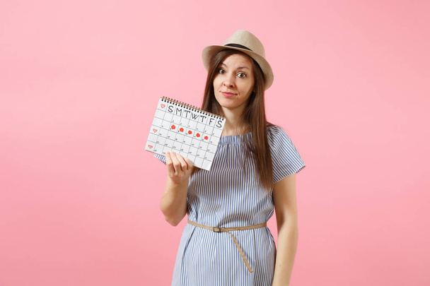 Ritratto di giovane donna in abito blu, calendario dei periodi di detenzione del cappello per controllare le mestruazioni isolate su uno sfondo rosa brillante e di tendenza. Concetto medico, sanitario, ginecologico. Copia spazio
 - Foto, immagini