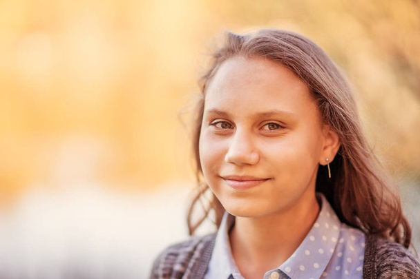 Portrait of a beautiful smiling girl with beautiful long hair in spring garden. - Valokuva, kuva
