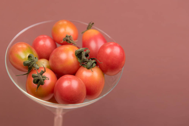 Cherry tomaten op een gekleurde achtergrond - Foto, afbeelding