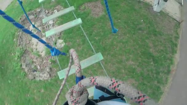 Girl in safety equipment in rope park - Materiał filmowy, wideo