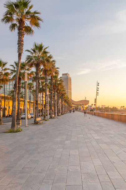 Barcelona, Spanien - 8. Juni 2018: Bürgersteig in Strandnähe in Barcelona bei Sonnenaufgang. - Foto, Bild