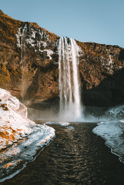 Wonderful landscape from Seljalandsfoss Waterfall in Iceland on a clear day with blue sky and snow. - Foto, immagini