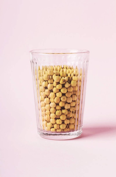Sojaproducten op roze achtergrond: droge bonen en vegan melk - Foto, afbeelding